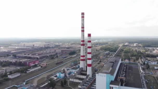 Съемка беспилотника тепловой электростанции с промышленными зданиями и дымоходами и градирнями на периферии города — стоковое видео