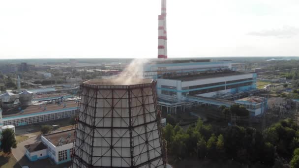 Drone filmato di una centrale termica e fumo da una torre di raffreddamento sullo sfondo di un paesaggio estivo. Inquinamento ambientale — Video Stock