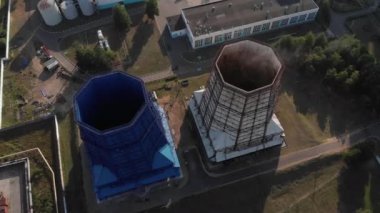 Güneşli bir gökyüzünün zeminine karşı termik santralin bölgesindeki soğutma kulesi dumanının ve endüstriyel binaların en üst görüntüsü