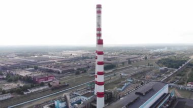 Şehrin çevresindeki sanayi binaları, bacaları ve soğutma kuleleri olan bir termik santralin insansız hava aracı görüntüleri.