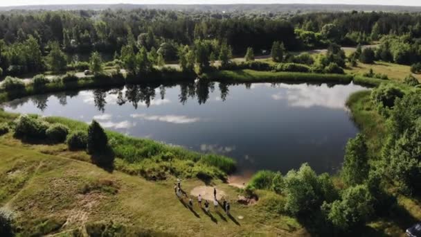 Hermosa vista superior de un paisaje de verano con lagos entre árboles y un reflejo del cielo en un lago con un grupo de personas en la orilla — Vídeos de Stock