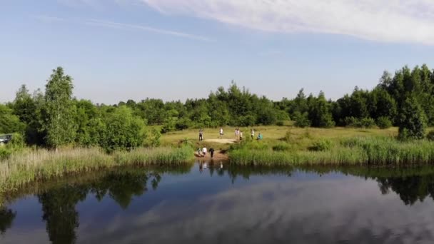 Misk, Belarus - August 15, 2020: Quadcopter shooting of a happy young man emerging from the lake after the baptism ceremony — Stock Video