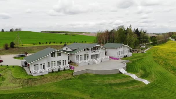 Bovenaanzicht van een prachtig landhuisje en de fotograaf die foto 's maakt van een bruid die naar boven rent — Stockvideo