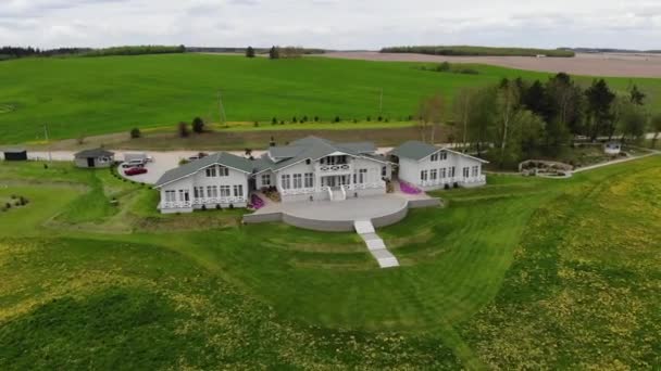 Tragerea cu drone a unei case de țară cu paturi de flori frumoase pe fundalul pajiștilor verzi într-o zi de vară — Videoclip de stoc