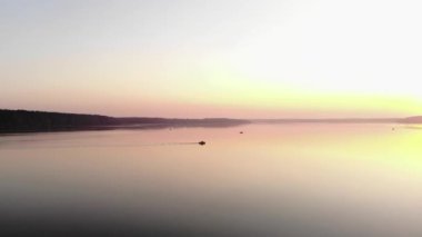 Güneşin batışında, gölün geniş yüzeyinde balıkçılarla dolu teknelerin havadan görünüşü. Hobi konsepti