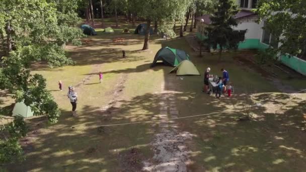 Misk, Bielorussia - 15 agosto 2020: Veduta aerea di un gruppo di persone vicino alle tende dei vacanzieri con bambini in una bellissima tenuta circondata da foreste in una giornata estiva — Video Stock