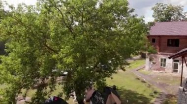 Ormandaki bir arazinin insansız hava aracından, otların üzerinde çadırlar ve orman ile çevrili bir nehrin manzarasıyla ateş etmek.