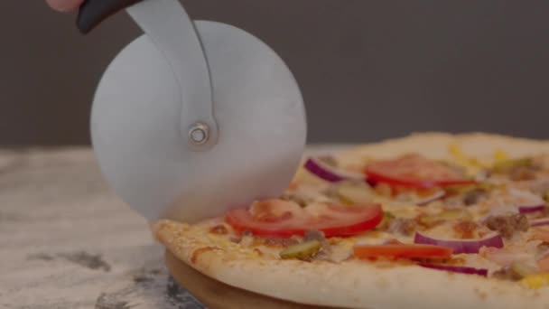 Šéfkuchař krájí pizzu speciálním nožem na dřevěné desce. Detailní záběr — Stock video