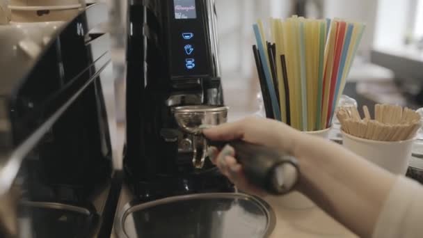 Nahaufnahme einer professionellen Kaffeemaschine auf einem Tresen in einem Café und einer Barista, die Kaffee einschenkt — Stockvideo