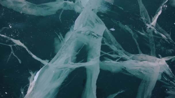 冬の日にバイカル湖の透明な凍結氷の上に見事なパターンと亀裂。閉鎖 — ストック動画