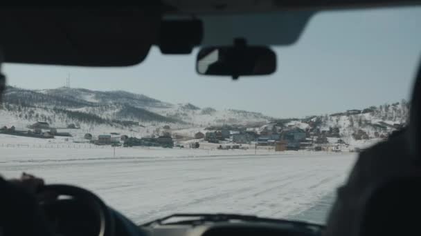 Uitzicht door de voorruit van een auto op een drukke snelweg omgeven door besneeuwde bergen tijdens een wintertocht — Stockvideo