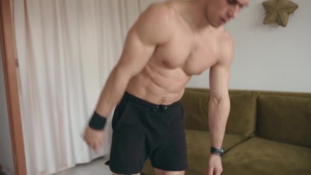 Schöne junge Bodybuilderin trainiert zu Hause und macht Plank auf der Matte mit Liegestützen und Schwungbeinen — Stockvideo