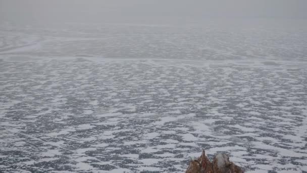 Panoramatický pohled na rozmarné vzory na ledě zamrzlého jezera Bajkal a s kameny v popředí — Stock video
