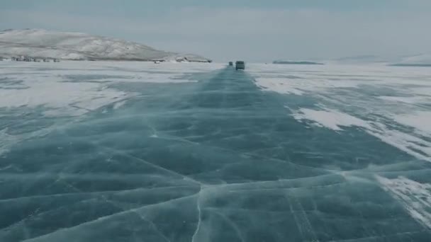 Вид на прозрачный лед в белых трещинах озера Байкал через лобовое стекло автомобиля, движущегося на высокой скорости — стоковое видео