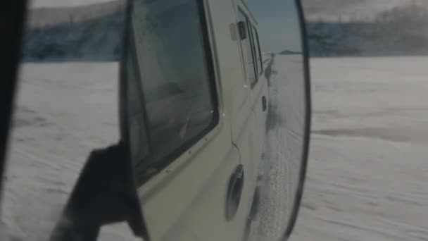 Відбиття у бічному дзеркалі мінібуса УАЗ, що рухається по замерзлому озері Байкал. Знімок порцеляни. — стокове відео