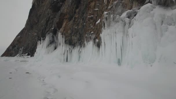 Stunning view of the rocky mountains on the shores of Lake Baikal with huge hanging icicles and icy foothills — Stock Video