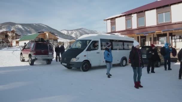 Baikal, région d'Irkoutsk, Russie - 18 mars 2021 : Des voitures ont amené des touristes et des gens à l'hôtel du village lors d'un voyage d'hiver — Video