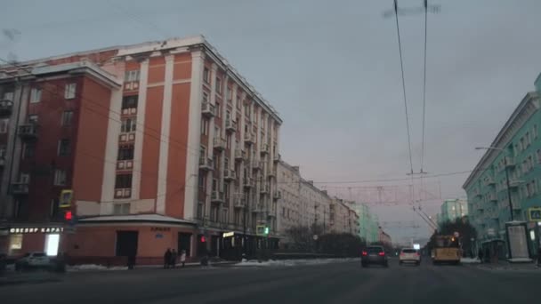 Murmansk, Russia - 10 gennaio 2021: Traffico intenso e belle case lungo la strada nella città invernale dall'interno della macchina. Colpo palmare punto di vista della fotocamera — Video Stock