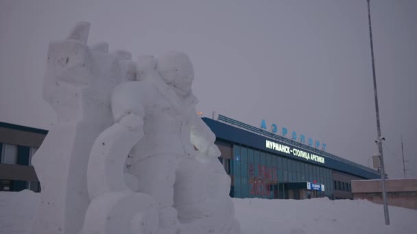 Murmansk, Ryssland - 10 januari 2021: Figur av en snowboardåkare ur snön nära ingången till den federala flygplatsen — Stockvideo