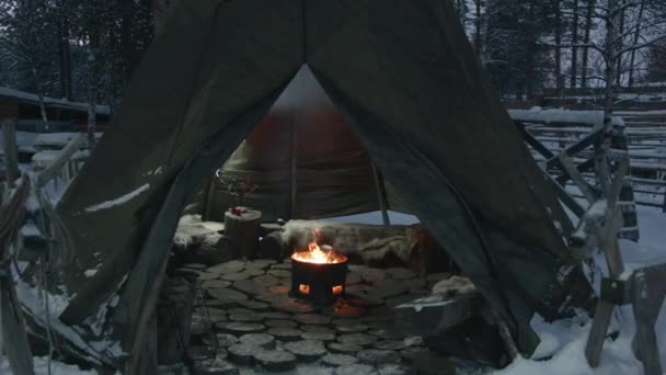 Blick auf ein offenes Feuer in einer eisernen Feuerstelle inmitten eines mit Pergwam bedeckten Zeltes im Winterhof — Stockvideo