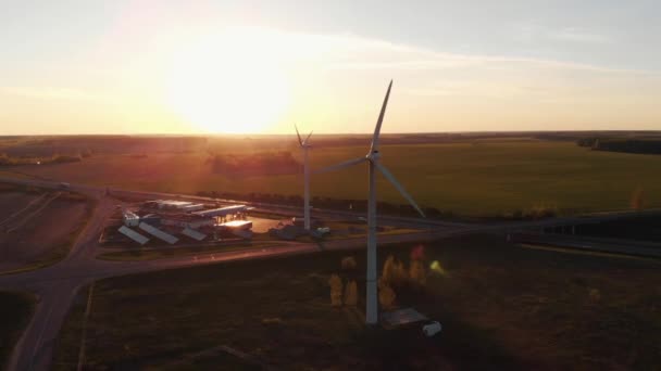 Minsk, Bielorussia - 20 maggio 2021: Veduta aerea delle pale rotanti di un mulino a vento sullo sfondo del tramonto e della stazione di servizio con pannelli solari — Video Stock