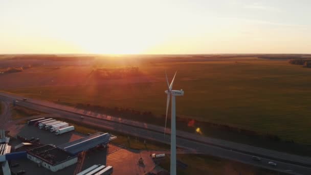 Minsk, Weißrussland - 20. Mai 2021: Luftaufnahme einer rotierenden Windmühle bei Sonnenuntergang und Sonnenkollektoren an einer vorstädtischen Tankstelle — Stockvideo