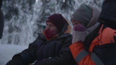 Murmansk, Rusya - 10 Ocak 2021: Genç bir kız kış ormanında bir adamın yanında oturuyor. Düşünce ve dinginlik kavramı