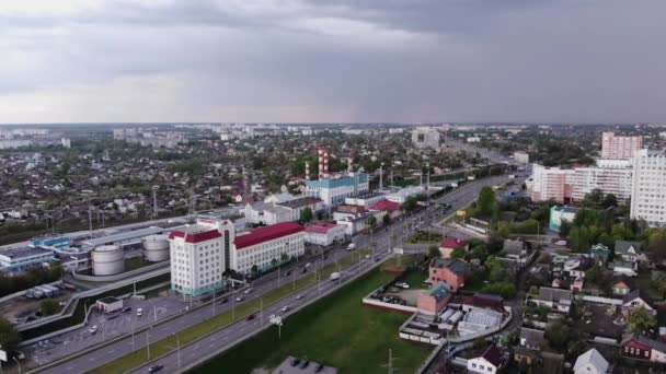 Widok z lotu ptaka ruchu drogowego w mieście z dzielnic mieszkalnych i fabryki w pobliżu autostrady — Wideo stockowe