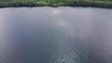 Nehirdeki teknede, yatları ve şehir manzarası olan bir çiftin hava görüntüsü.