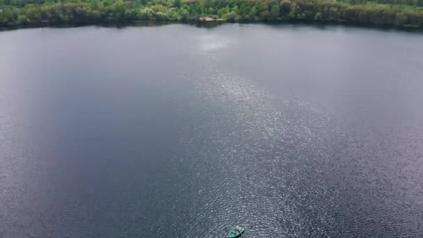 Vista aérea de una pareja en un barco sobre el río en las literas con yates y un panorama de la ciudad en la distancia — Vídeos de Stock