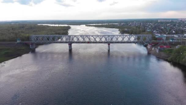 Drone tournage d'un panorama d'une partie de la ville et vue sur les ponts routiers et ferroviaires doubles à travers la rivière — Video