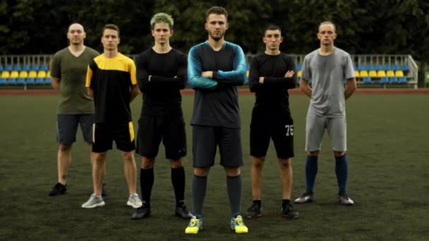 Fotbollslag spelare posera efter träning på stadens stadion med armarna vikta över bröstet — Stockvideo