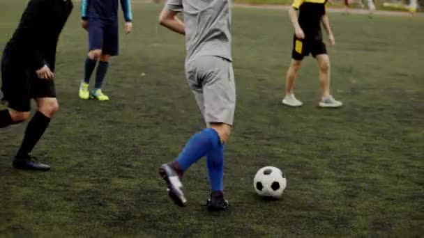 Los jugadores del club de fútbol entrenan en el estadio de la ciudad y pasan los momentos de juego dividiéndose en equipos. Movimiento lento — Vídeos de Stock