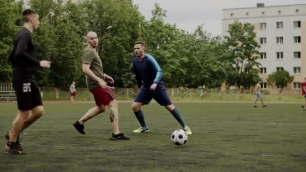 Los jugadores del club de fútbol se dividen en equipos y juegan al fútbol entre sí en el entrenamiento. Movimiento lento — Vídeos de Stock