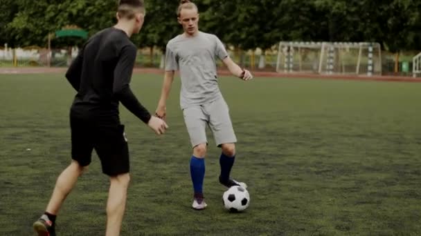 Los atletas del club de fútbol entrenar y jugar en el césped artificial de fútbol del estadio de la ciudad. Movimiento lento — Vídeos de Stock