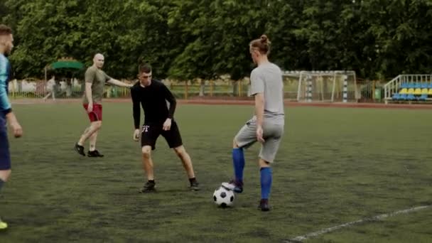 Fotbollslaget tränar på stadens stadion en sommardag och spelar fotboll sinsemellan. Långsamma rörelser — Stockvideo