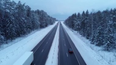 Otobanda araçlara ateş eden hava aracı yolun kenarında karlı bir ormanla farklı yönlere gidiyor.