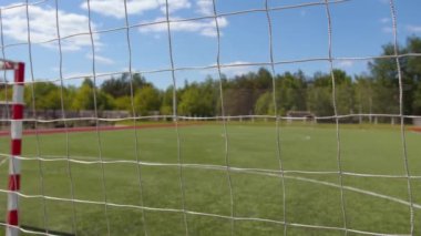 Şehir parkındaki boş bir futbol sahası. Naylon çitin içinden. Geniş kare hücreli.