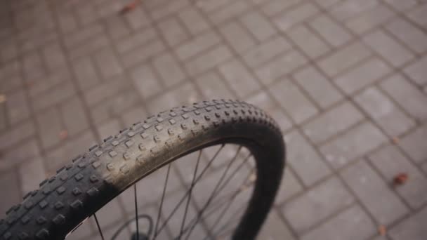 Primer plano de una parte de una rueda de bicicleta deportiva en una pista de baldosas de la ciudad en un día soleado — Vídeo de stock
