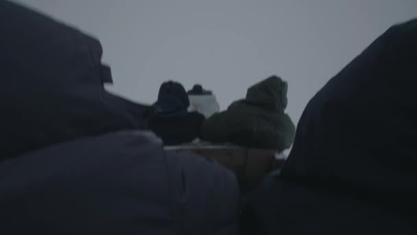 남자들은 썰매를 타고 기차를 타고 안개가 자욱 한 눈밭을 가로지른다. 뒷 쪽을 봐. 손에 들고 찍은 카메라 사진 — 비디오