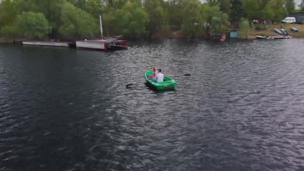 Vedere aeriană a unui cuplu tânăr îndrăgostit care se plimbă cu barca pe râu într-o zi de vară — Videoclip de stoc
