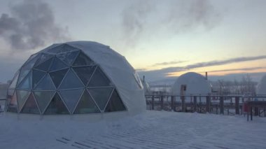 Orijinal kubbeli eskimo evleri. Panoramik camlı pencereleri kışın arka planına karşı.