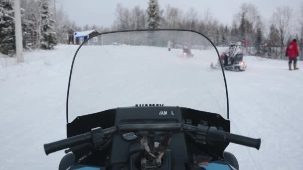 Tiroteio dos motoristas assento como uma coluna de motos de neve com turistas se transforma em uma estrada da floresta — Vídeo de Stock