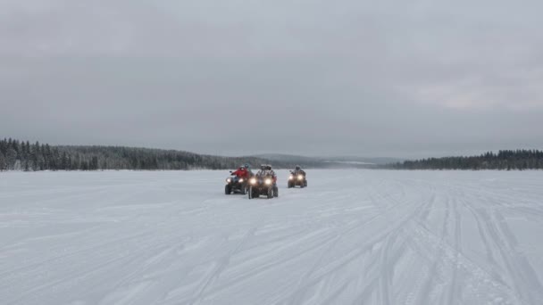 Murmanskin alue, Venäjä - 10. tammikuuta 2021: Ryhmä turisteja ajaa nelipyöräisillä pyörillä kauniin talvimaiseman taustalla. Hidastus — kuvapankkivideo