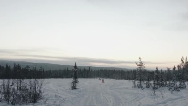 Panorama de paisagem de inverno e turistas em motos de neve que montam em uma coluna. Pontos de mão tiro — Vídeo de Stock
