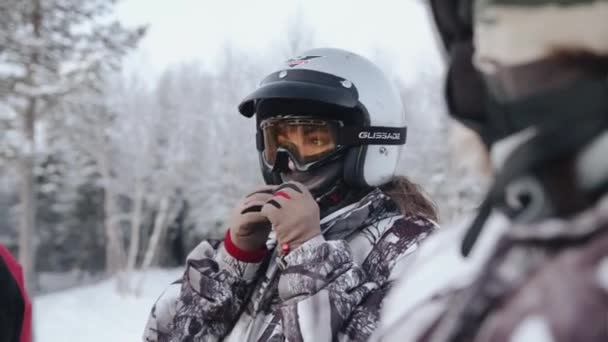 Wilayah Murmansk, Rusia - 10 Januari 2021: Potret seorang gadis muda dengan helm karena mengendarai mobil salju mengoreksi topeng angin di wajahnya. Gerakan lambat — Stok Video