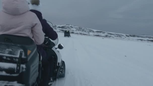 Murmansk region, Russia - January 10, 2021: Two young girls ride a snowmobile. Back view. Handheld pov shot — Stock Video