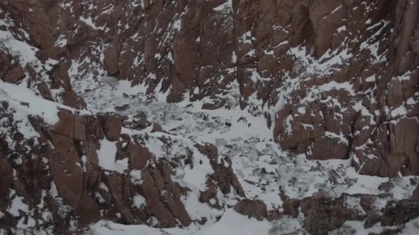 Замерзший водопад в ущелье большой скалистой горы и замерзшие потоки воды на каменных ступенях каньона — стоковое видео