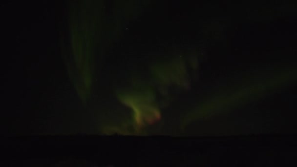 Aurora borealis. Захватывающий вид на зеленые и сиреневые вихри северного сияния в ночном небе над полярным кругом — стоковое видео