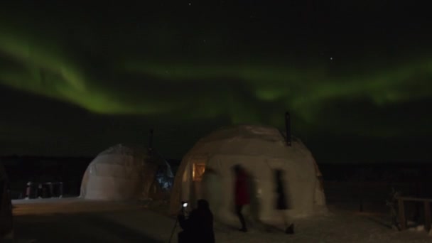 I turisti sulla piattaforma circa igloo stanno filmando le luci del nord nel cielo notturno con le loro telecamere e telefoni. Sparatoria veloce — Video Stock